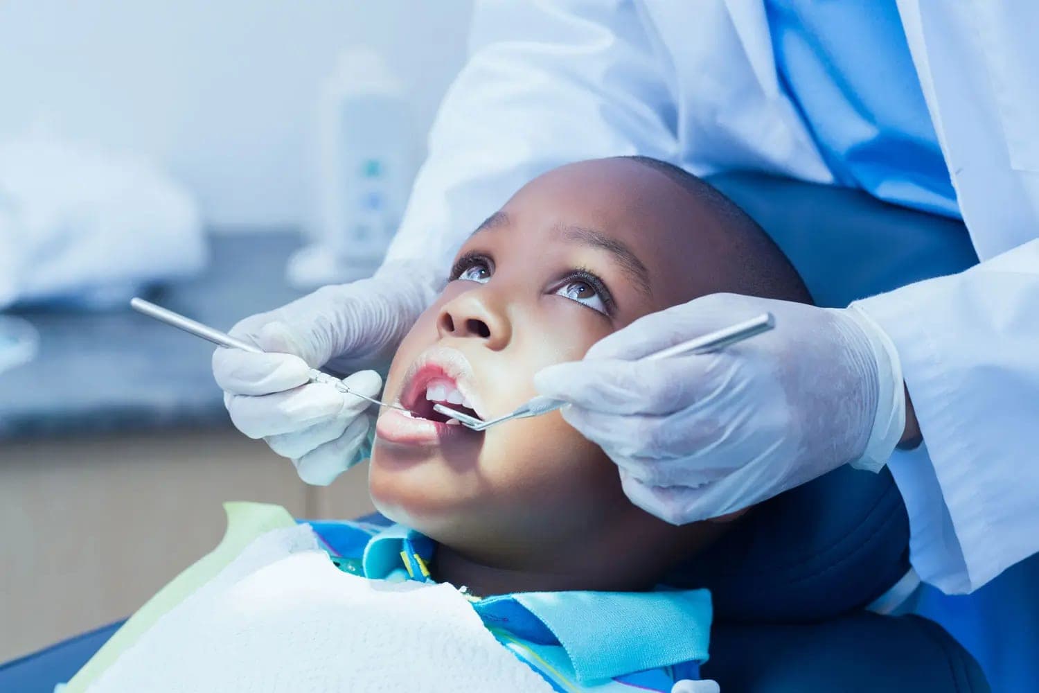 A child having a check-up, the dentist working with mirror and probe