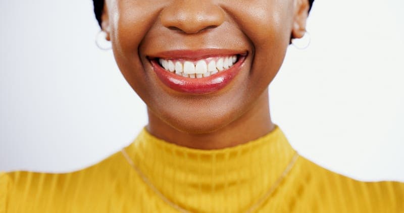 A woman smiling, her teeth healthy and even