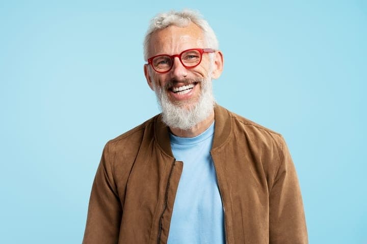 An older man smiling, his teeth restored and even